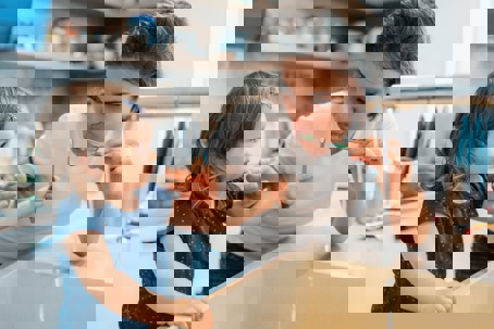 a mother and daughter toothbrushing